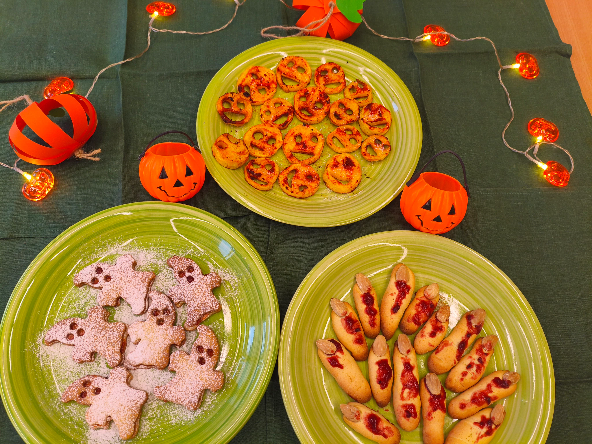 Tři talíře s halloweenským pečivem mezi dekoracemi s dýněmi.
